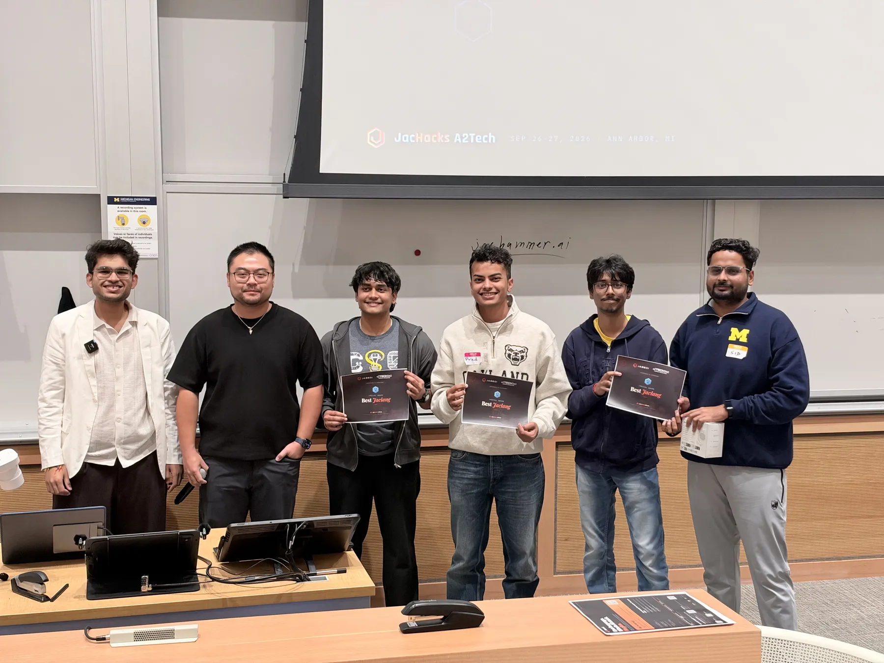 Winning team with certificates on stage at JacHacks A2Tech